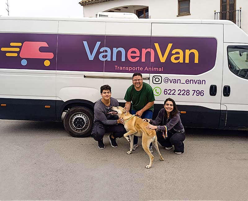 Dos hombres y una mujer con un perro delante de una furgoneta  VanenVan Transporte animal.