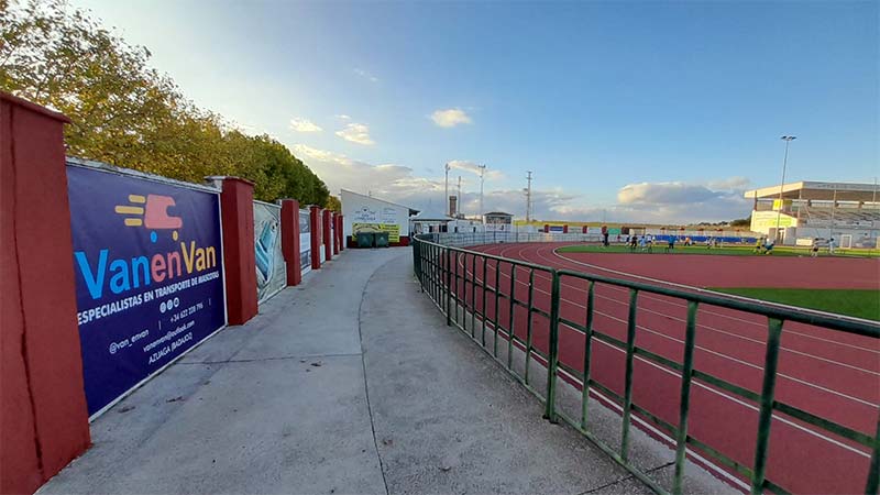 VanenVan patrocinio CD Azuaga Pista de atletismo con un cartel que dice "VanenVan", destacando el nombre en un entorno deportivo.